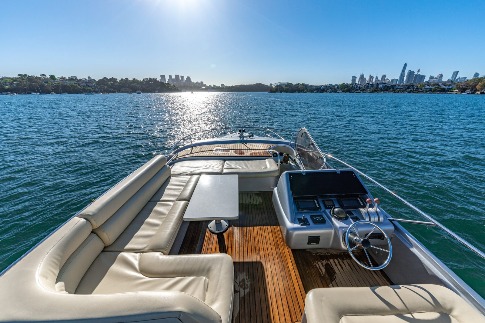 Stern lounge with timber table and city view from MV Sunseeker.