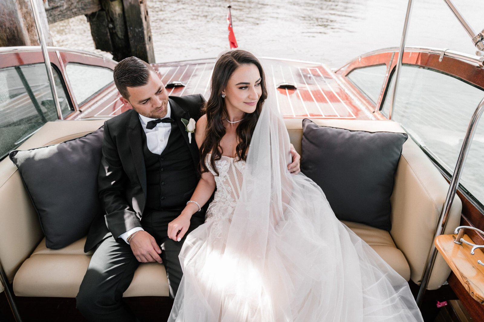 Bride and groom sitting together on a luxury wedding boat in Sydney Harbour.