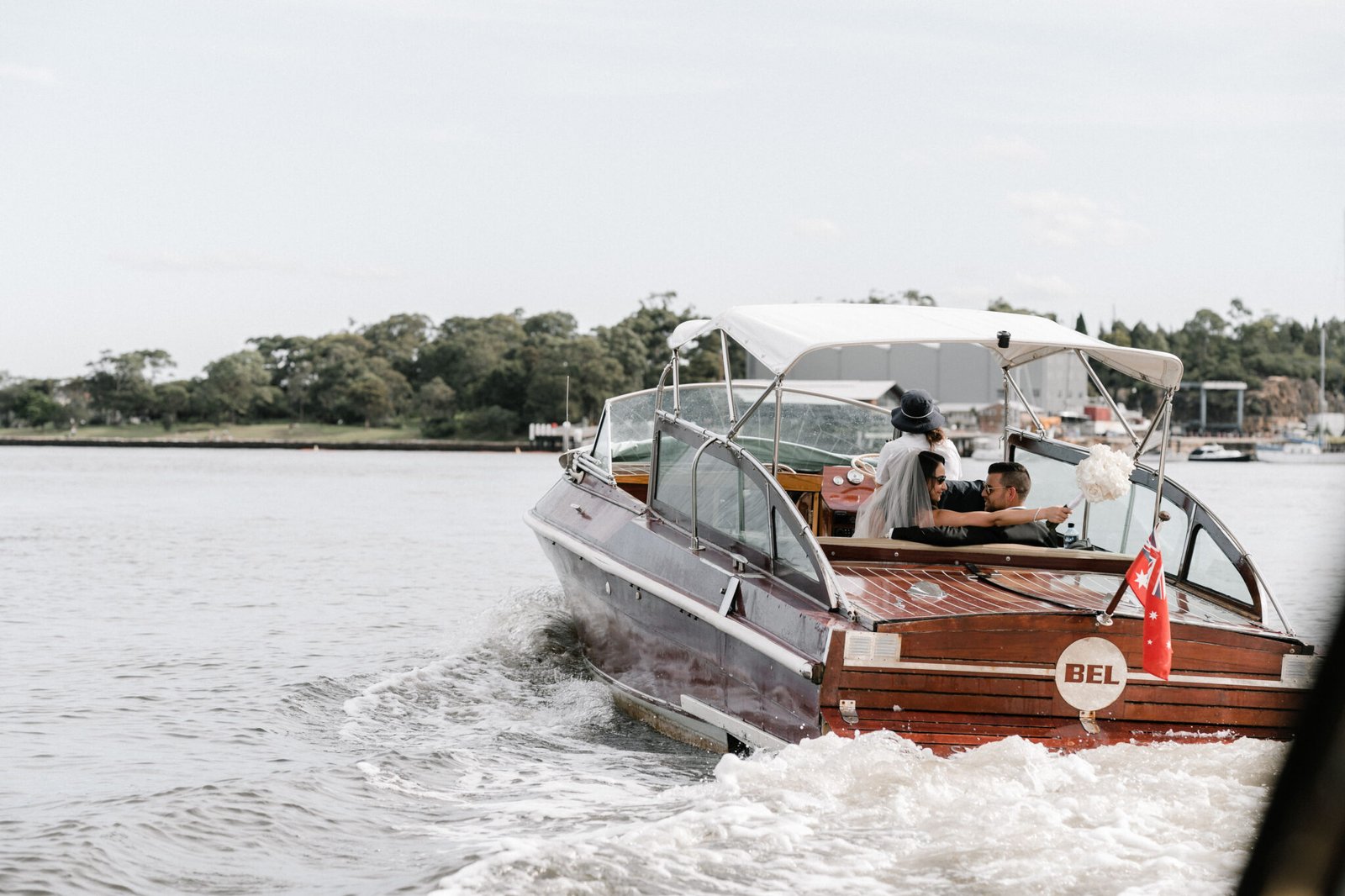Classic wooden yacht speeding through Sydney Harbour for a wedding transfer.