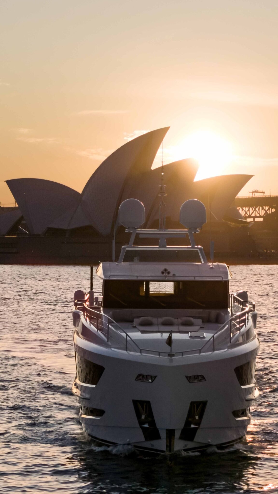 View from the bow of a yacht with a sunset in the background.