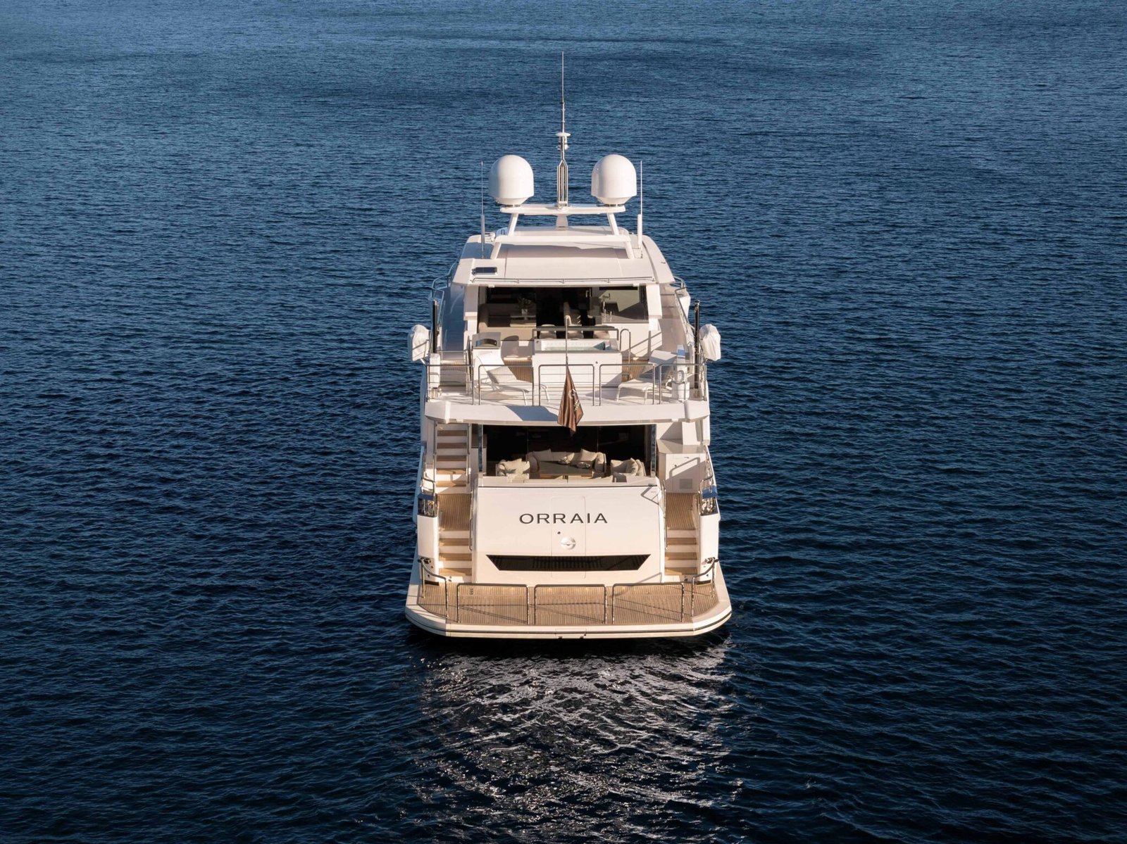 Drone shot of the stern of a yacht, showcasing its deck and rear design