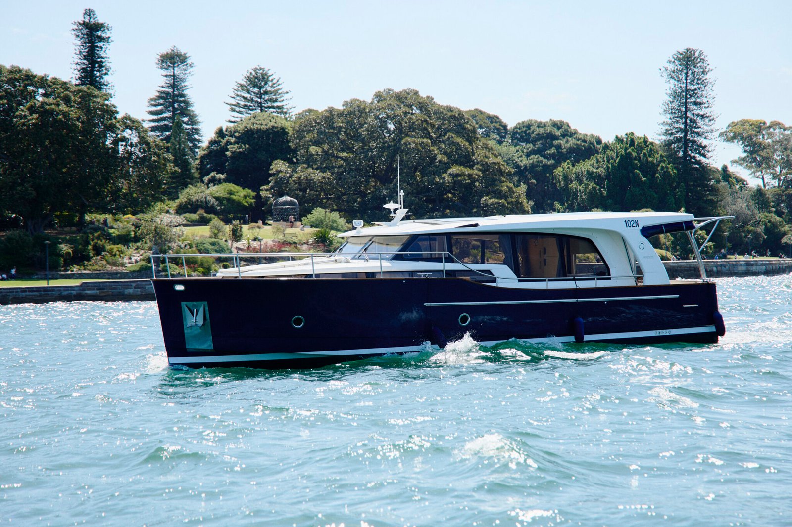 Hybrid-electric yacht EV Arcadia gliding across Sydney Harbour, with the Sydney Opera House and city skyline in the background.